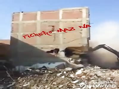 Building falls on top of excavator