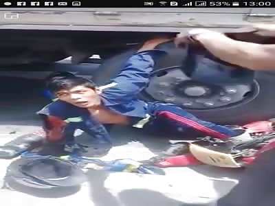 COUPLE OF ADOLESCENTS UNDER THE TRUCK