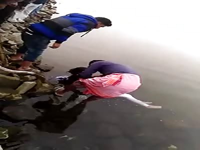 REMOVING THE BODY OF THE WOMAN FROM THE RIVER