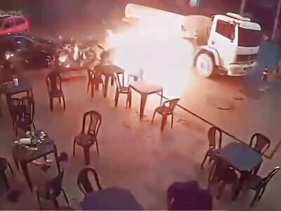 IDIOT LIGHTS CIGARETTE NEXT TO TRUCK SUPPLYING THE GAS STATION