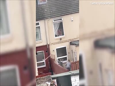 Plank wars! Two neighbours fight with wooden planks over garden fence